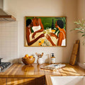 Framed artwork of three women sharing wine, oysters and citrus above a wood kitchen counter