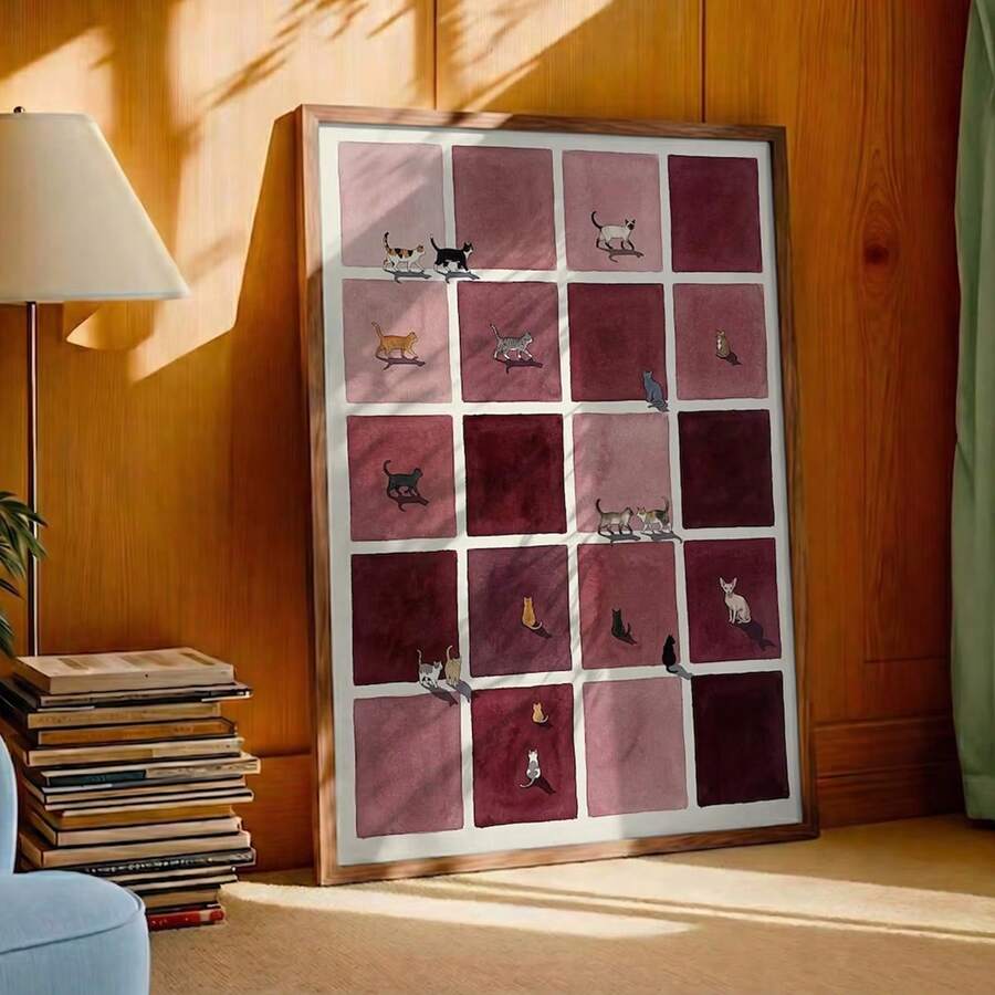 Burgundy checkerboard cat grid canvas poster in wood frame beside books