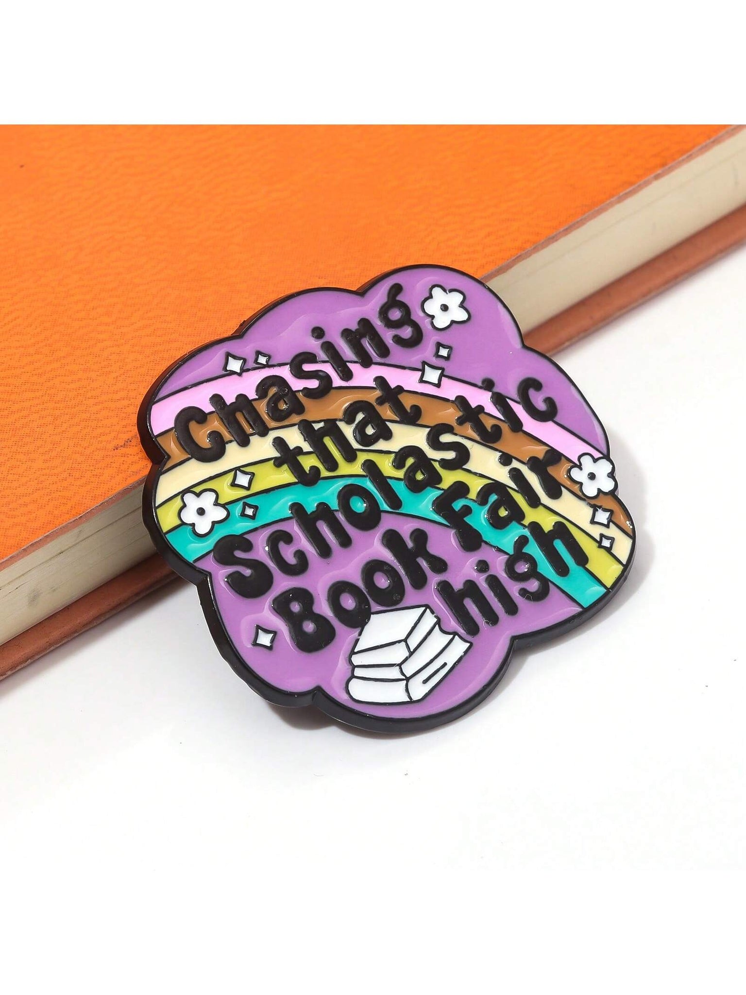 Upgrade your style with our Chasing Scholastic Dreams book fair brooch pins. Made with vibrant enamel, these pins are perfect for showcasing your love for literature. Add a touch of fashion to your outfit while inspiring others to chase their dreams.