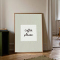 Framed coffee please striped wall print leaning by a doorway and stacked books
