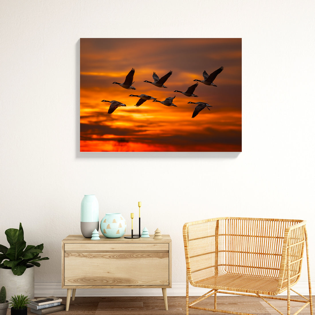 Capture the serene beauty of nature with this striking canvas wall art featuring a flock of geese silhouetted against a vibrant orange sunset sky. This wildlife photography piece brings warmth and movement to any space, making it an ideal focal point for living rooms, bedrooms, or above sofas.