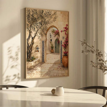 Framed Mediterranean courtyard artwork hanging above a sunlit dining table