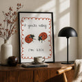 Black-framed ladybug canvas poster with rust scalloped border above a wood sideboard