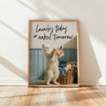 Sunlit framed mockup of white cat laundry art beside an overflowing wicker basket