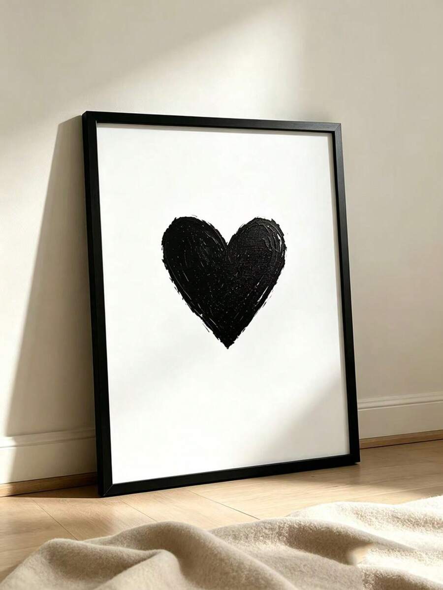 Textured black heart on white canvas shown in a slim black frame leaning against a wall. Heart Shaped Graffiti Abstract Black & White Canvas Poster