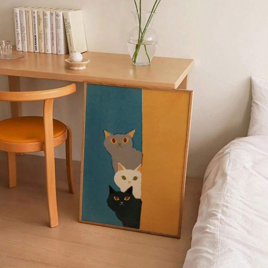 Three stacked cats in teal and mustard wall art beside a modern bedroom desk