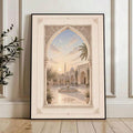 Black framed courtyard arch artwork with fountain and crescent sky against a white paneled wall