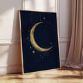 Tall pale gold framed navy moon and stars artwork leaning beside a blush curtain on a sunlit herringbone floor