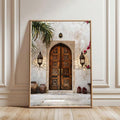 Light wood framed architectural print with carved arched double door lanterns white steps palm leaves pink flowers and red lanterns