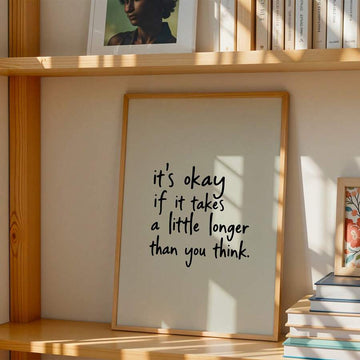 Handwritten it is okay quote canvas poster on a sunlit bookshelf