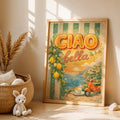 Light wood framed Ciao Bella Italian coastal poster with lemons, sea and orange scooter beside woven basket and plush rabbit