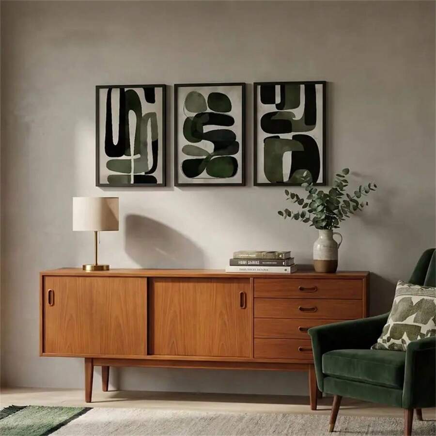 Three olive abstract prints above a walnut mid-century sideboard