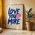 Framed Love You More blue lettering print by plant and mustard curtain