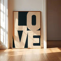 Framed cream and navy geometric LOVE poster in a sunny doorway