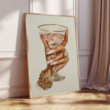 Gold-framed luxury cocktail hand canvas poster leaning beside blush curtains on herringbone flooring