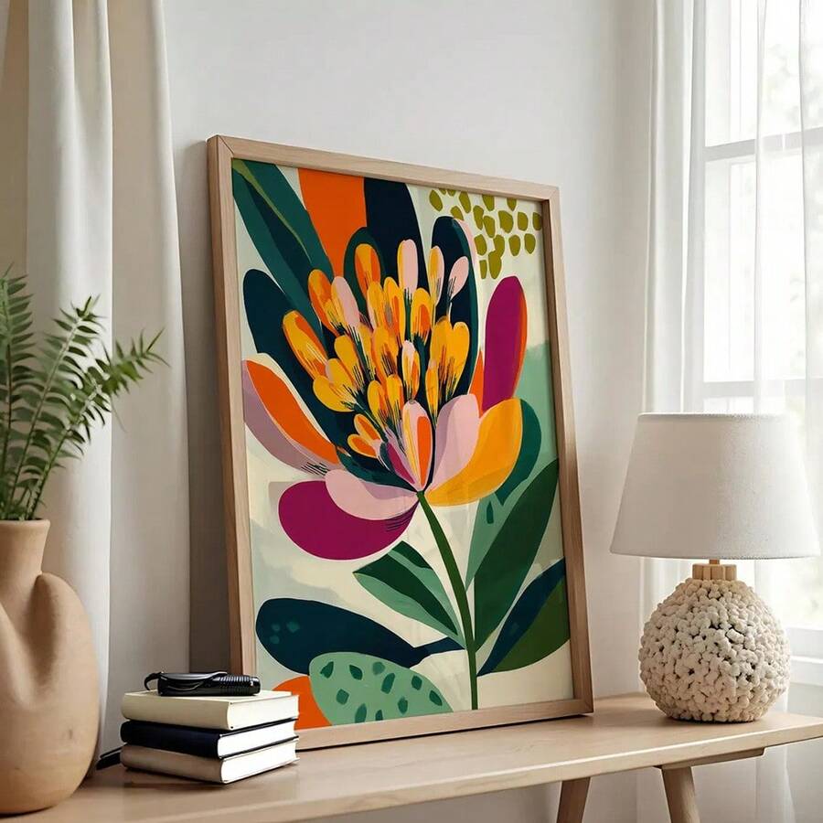 Colorful orange pink and burgundy floral bohemian canvas poster in a light wood frame on a console