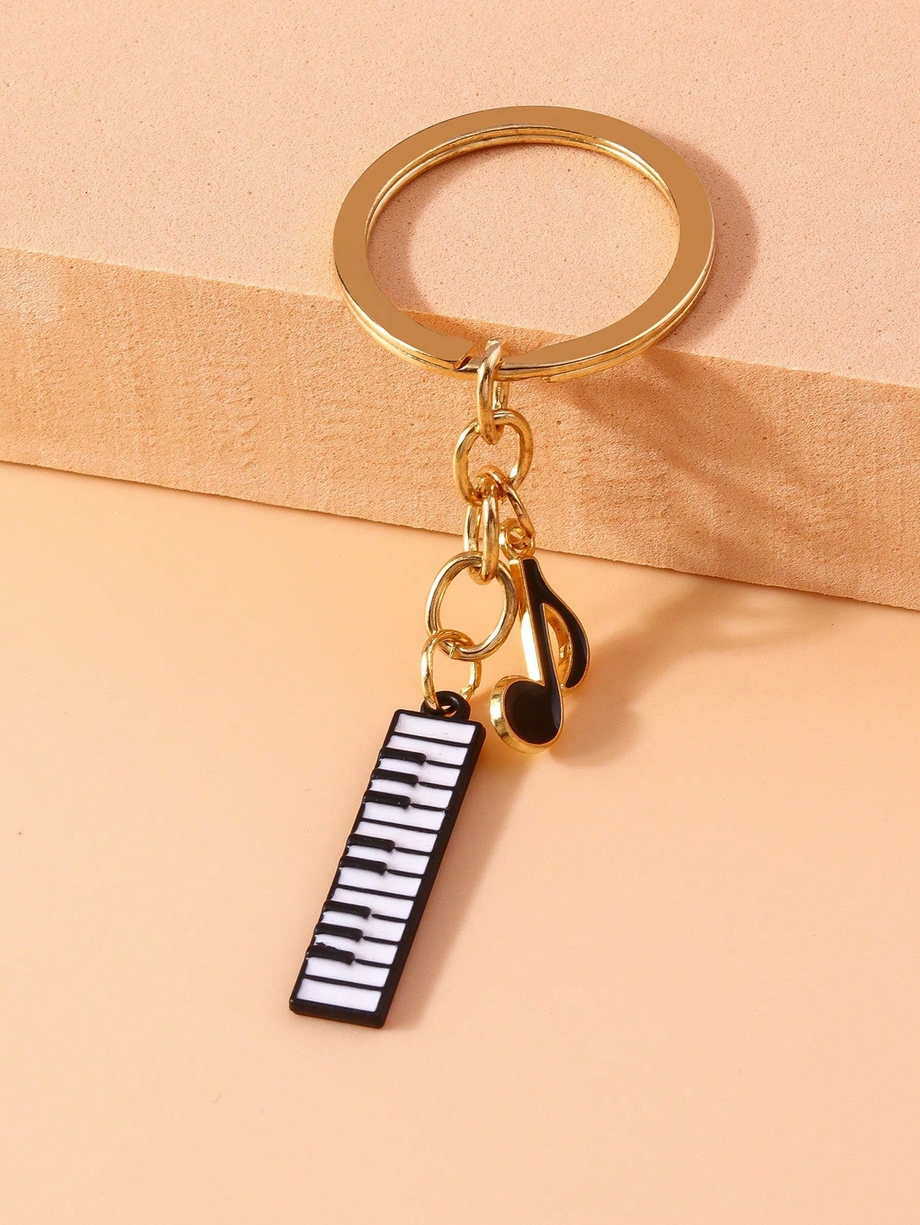 Add a melodic touch to your keys with the Melodic Charm keychain. This music-themed keychain features a piano design and a musical note pendant, perfect for music lovers and pianists alike. Show off your love for music and keep your keys organized with this unique and creative keychain.