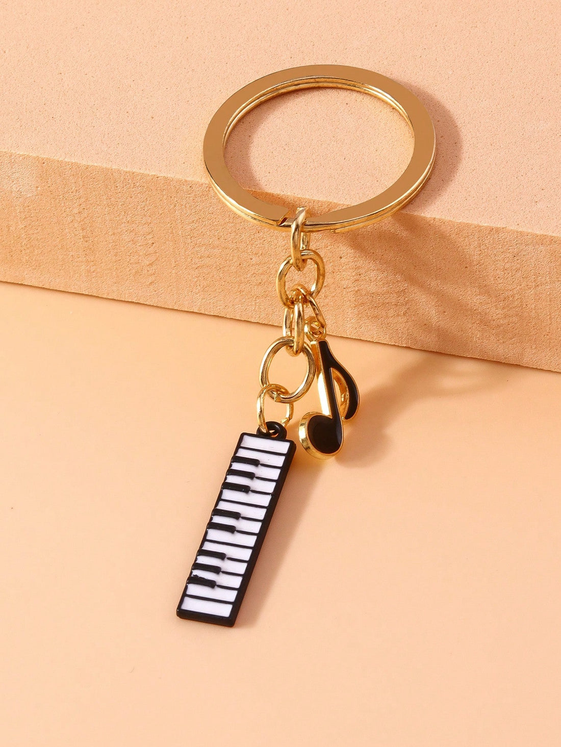 Add a melodic touch to your keys with the Melodic Charm keychain. This music-themed keychain features a piano design and a musical note pendant, perfect for music lovers and pianists alike. Show off your love for music and keep your keys organized with this unique and creative keychain.