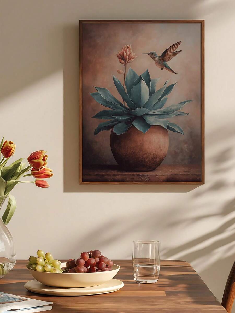 Framed hummingbird hovering over blue-green agave in a terracotta planter