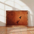 Black hummingbird wall art on terracotta desert gradient background