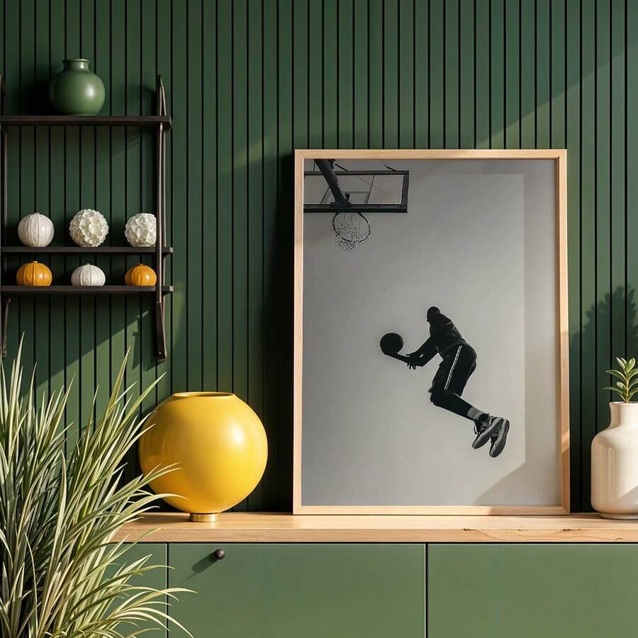 Black basketball dunk silhouette canvas poster in a wood frame above green cabinet decor