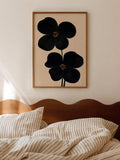 Black floral canvas art with two abstract flowers on beige background