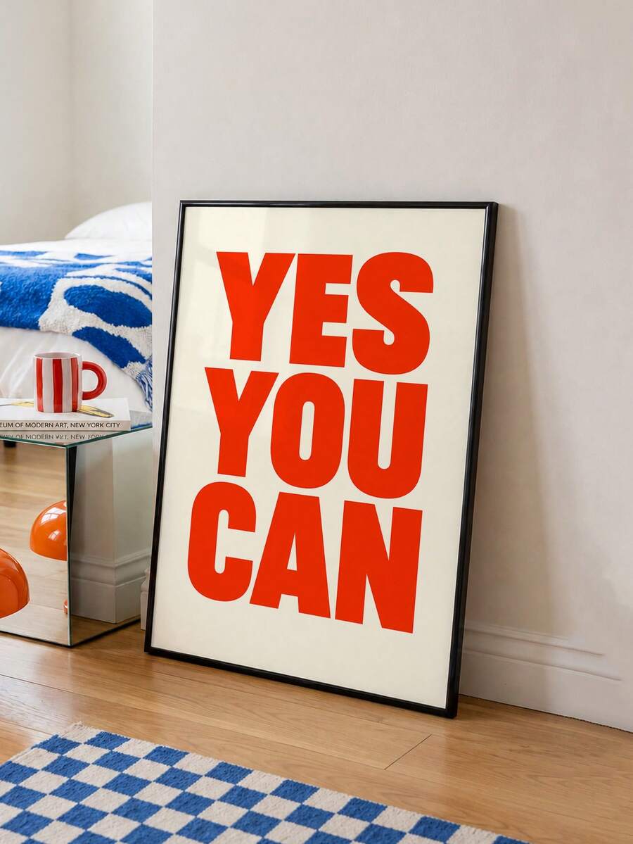Framed red YES YOU CAN typography canvas leaning by blue-and-white bedroom rug
