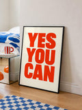 Framed red YES YOU CAN typography canvas leaning by blue-and-white bedroom rug
