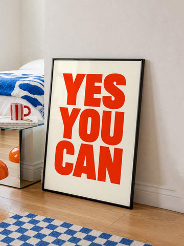 Framed red YES YOU CAN typography canvas leaning by blue-and-white bedroom rug