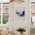 Pastel abstract framed wall art above cream sofa in bright living room