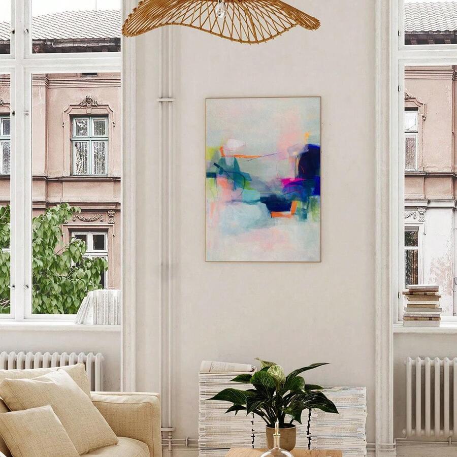 Pastel abstract framed wall art above cream sofa in bright living room