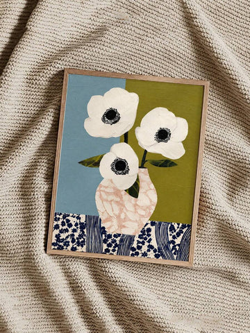 Three white anemones in a blush vase against blue and olive panels with navy floral border
