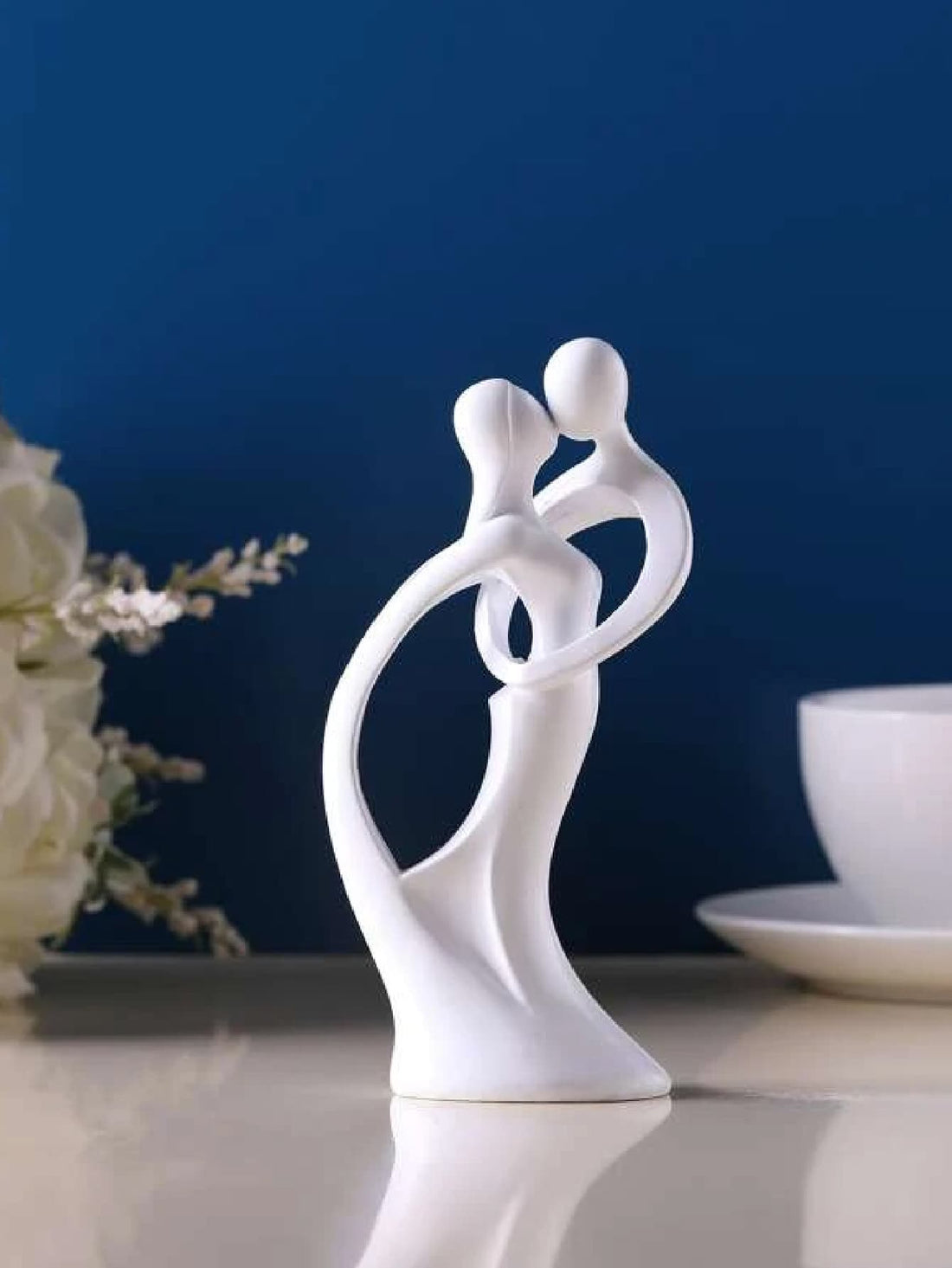 Add a touch of modern elegance to any room with this sandstone resin couple figurine. Perfect for home decor or as a thoughtful wedding gift, this minimalist design exudes sophistication and charm. Crafted from high-quality material, this figurine is a timeless addition to any space.