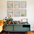 Six-piece pastel coastal wall art set above a green console