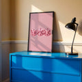 Pink heart dice canvas poster in a black frame above a blue cabinet