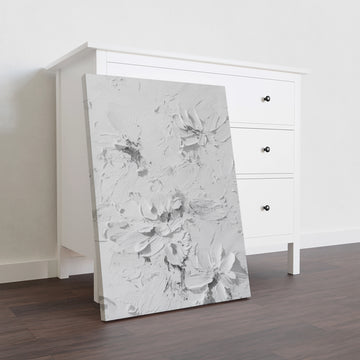 Elevate your interior with this contemporary canvas art piece, featuring delicate floral motifs rendered in sophisticated white tones against a textured background. The dimensional surface adds depth and visual interest, creating a refined focal point that complements modern and transitional décor styles. Versatile enough for living rooms, bedrooms, or entryway spaces, this artwork brings understated elegance to any wall.