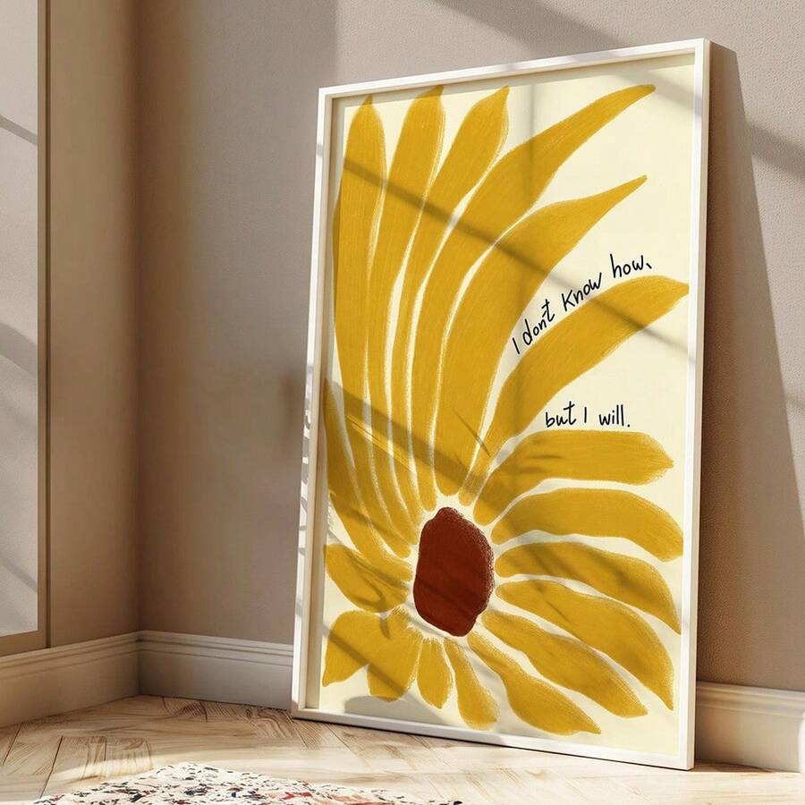 White-framed mustard sunflower quote print leaning against a sunlit beige wall