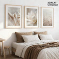 Neutral botanical triptych displayed above a bright bedroom bed