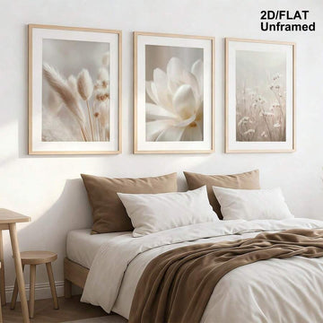 Neutral botanical triptych displayed above a bright bedroom bed
