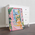 This lovely artwork features an orange cat reading by a window, set against a beautiful tropical pink garden scene. Perfect for decorating your living room, sofa backdrop, or bedside, this piece will add a charming touch to your home decor. Brighten up your space with this delightful combination of feline and floral elements.