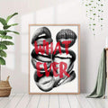 Large framed WHAT EVER lips poster on white floor with plants and throw nearby