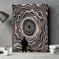 Optical vortex canvas poster with black concentric rings, colorful wavy bands and a silhouetted figure
