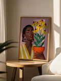 Botanical woman portrait with yellow flowers leaning beside a cream armchair