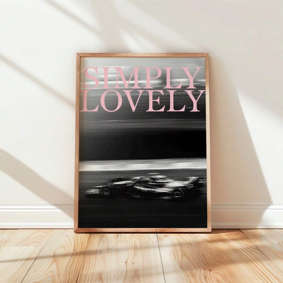 Framed black-and-white racing car poster with pale pink Simply Lovely lettering against a light wall