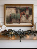 Framed brown horse in green plaid blanket at decorated rustic stable