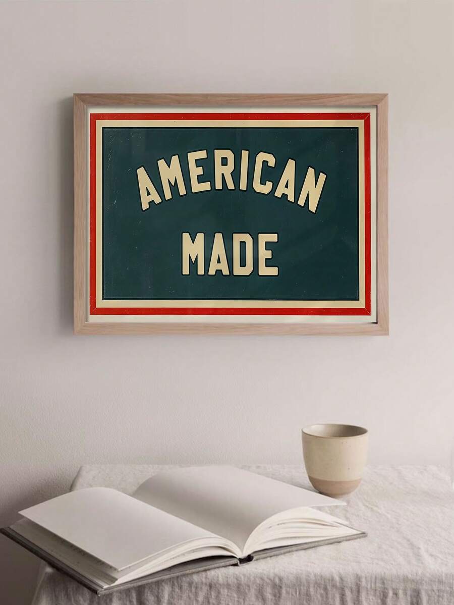 Framed AMERICAN MADE canvas with cream lettering on dark green and red border above a bed