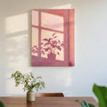 Pink botanical canvas print on dining wall above wood table with vase
