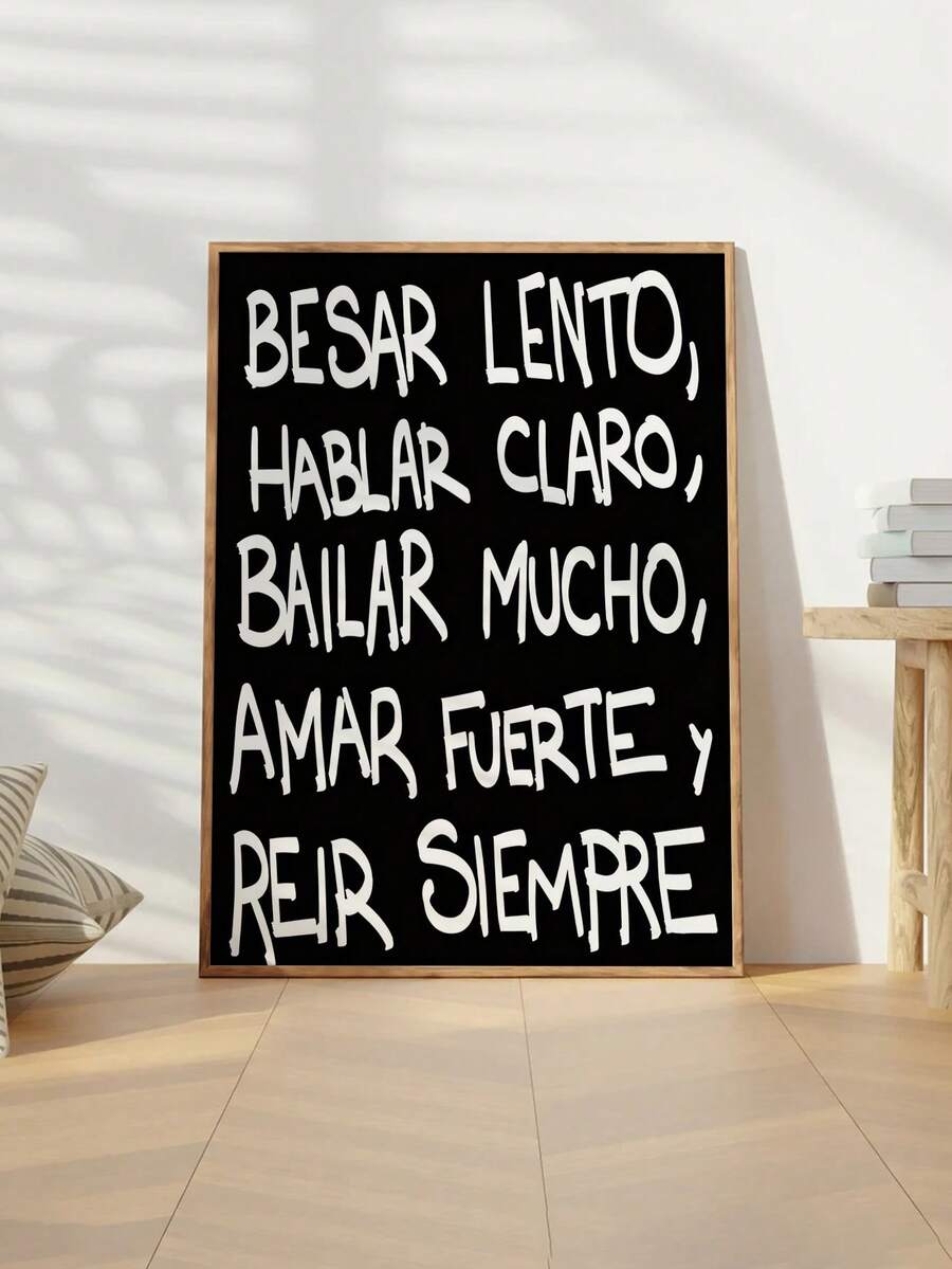 Framed black canvas with white Spanish quote “Besar lento, hablar claro, bailar mucho, amar fuerte y reír siempre”