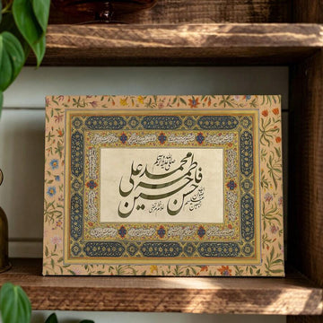 Arabic calligraphy canvas with ornate navy and gold floral border displayed on a wooden shelf