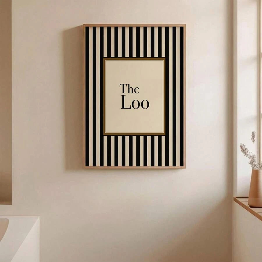 Framed The Loo typography print with black vertical stripes on cream bathroom wall